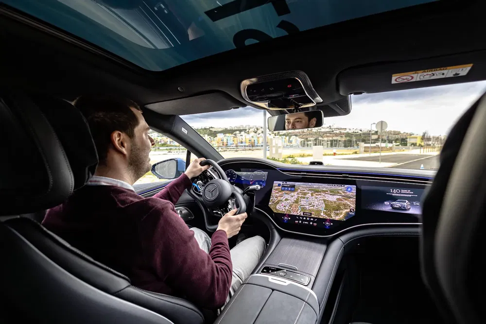 {"fr":"Conducteur utilisant la technologie avancée du tableau de bord d'une Mercedes EQS.","nl":"Bestuurder gebruikt geavanceerde dashboardtechnologie in een Mercedes EQS."}