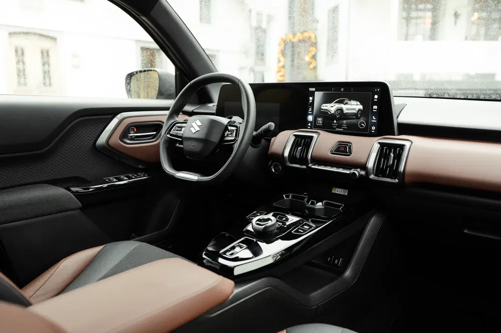 Modern Suzuki interieur met touchscreen en stijlvol lederen stuur.