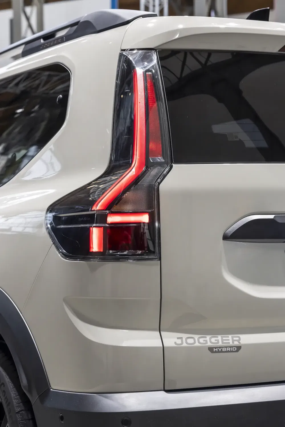 Close-up van de achterlichten van de beige Dacia Jogger Hybrid, modern en stijlvol.