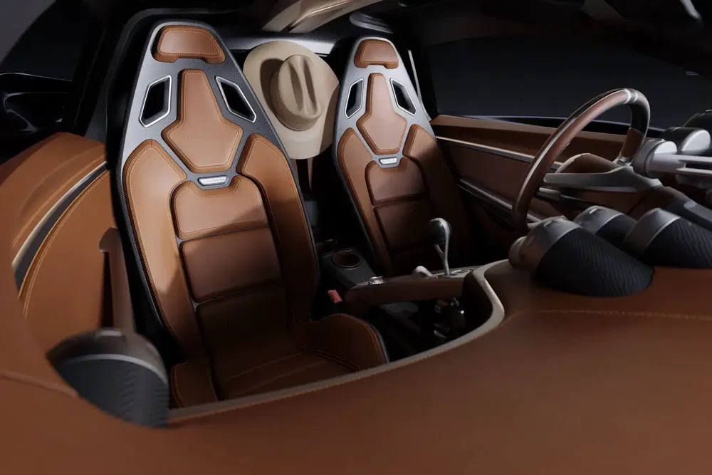 Intérieur de voiture sportive avec sièges en cuir marron et chapeau suspendu à l'arrière.