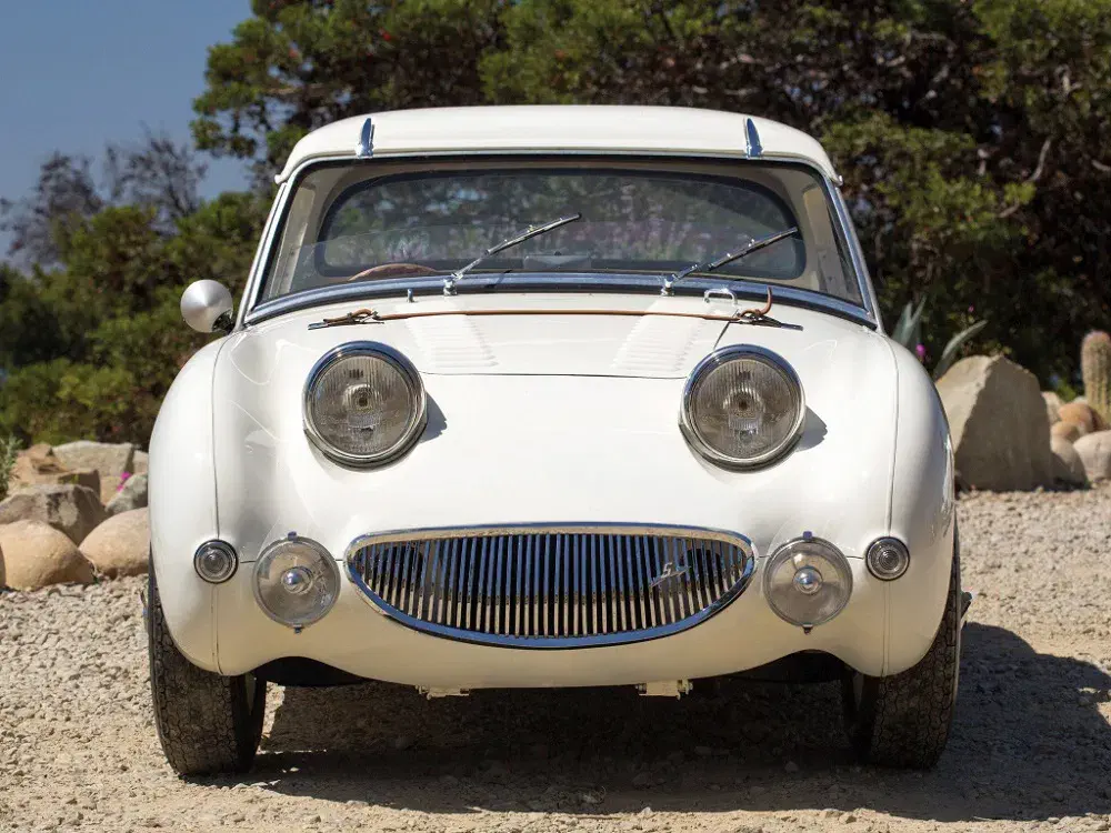 {"fr":"Austin-Healey Sprite 1958, voiture classique blanche, face avant unique et souriante.","nl":"Austin-Healey Sprite 1958, klassieke witte auto met uniek, glimlachend frontontwerp."}