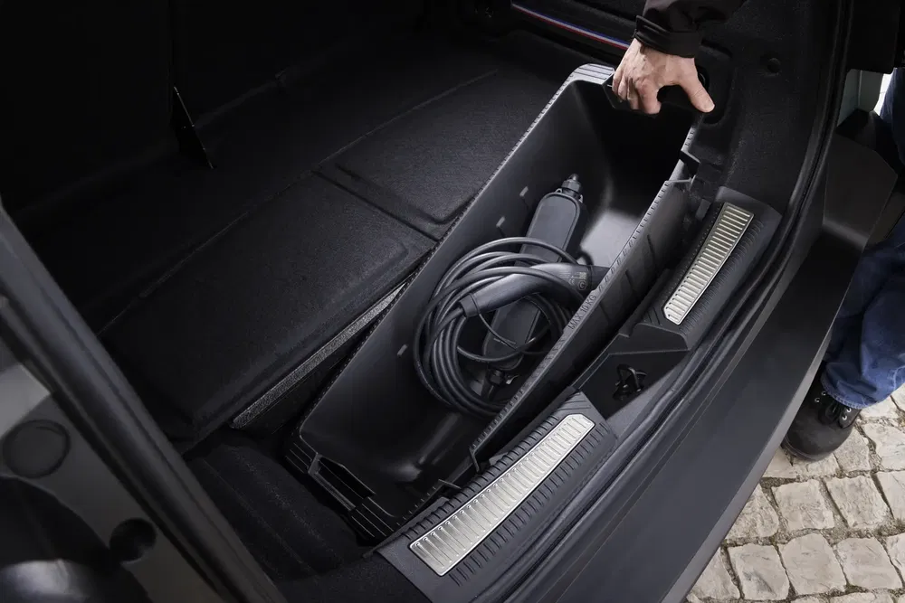 Kofferbak van auto met opbergvak voor elektrische oplaadkabel.