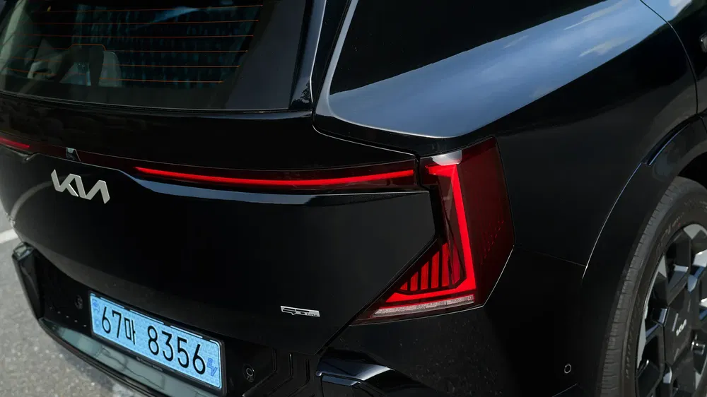 Arrière du Kia EV9 noir avec éclairage LED distinctif et plaque coréenne visible.