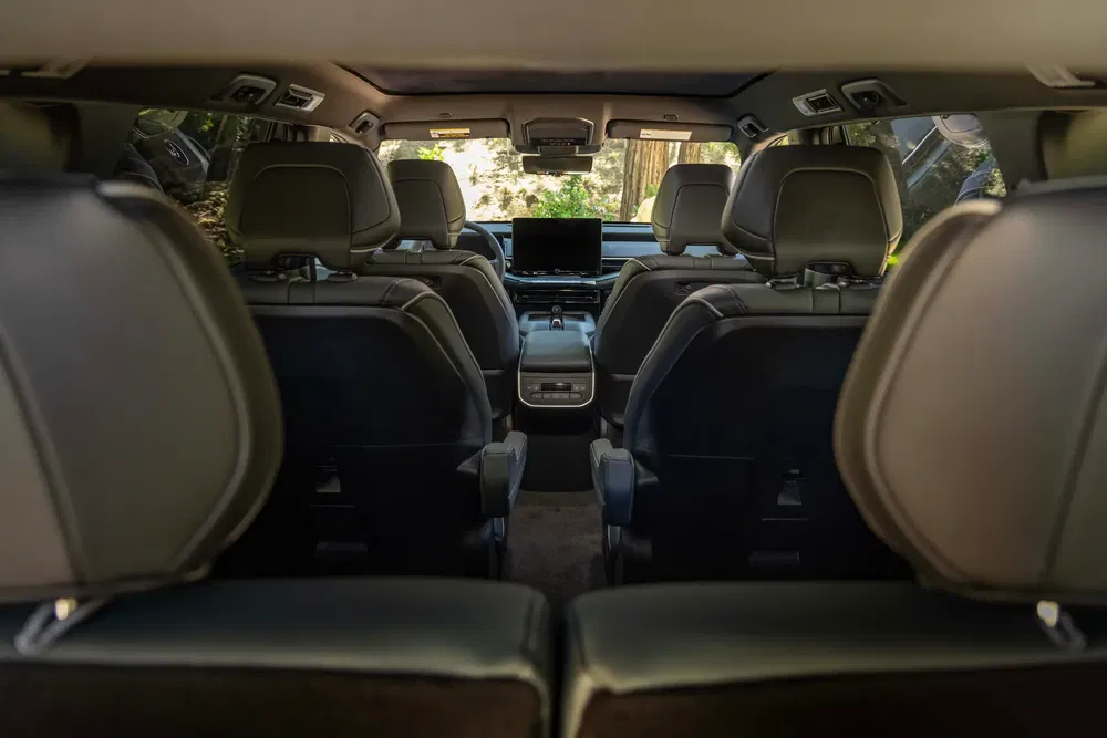Intérieur spacieux d'un SUV, avec trois rangées de sièges et un écran central avant.