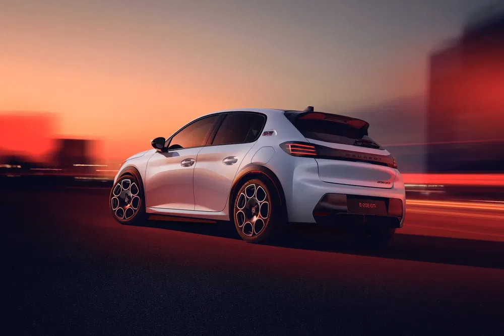 Voiture blanche électrique en mouvement sur une route au crépuscule avec arrière plan flou.