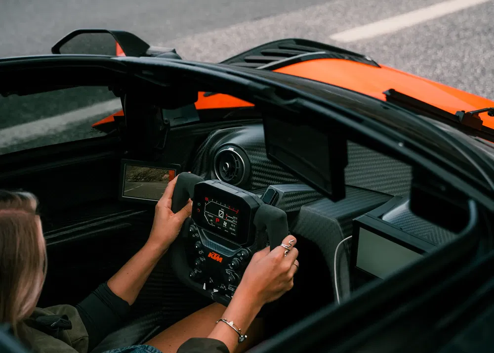 Sportief interieur van een KTM met geavanceerd stuur en digitaal dashboard.