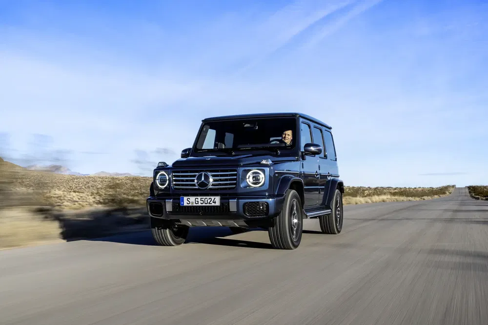 Mercedes-Benz G-Klasse rijdt op een zonnige woestijnweg.