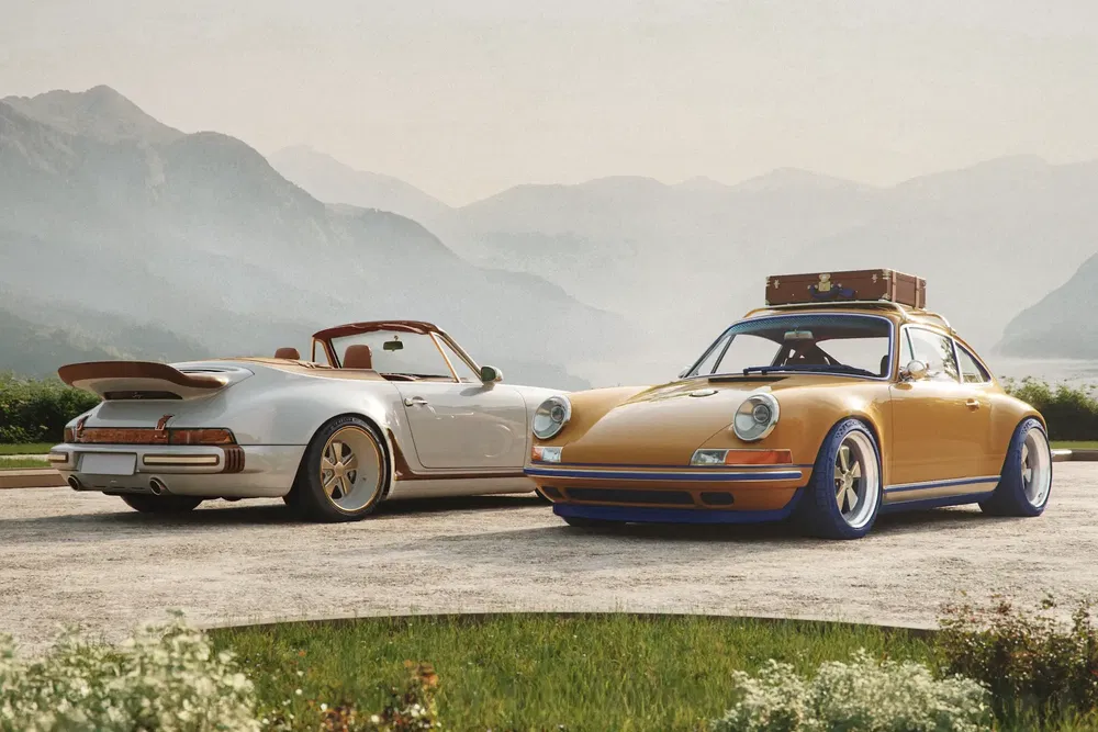 Deux Porsche classiques stationnées dans un paysage montagneux, l'une avec bagage sur le toit.