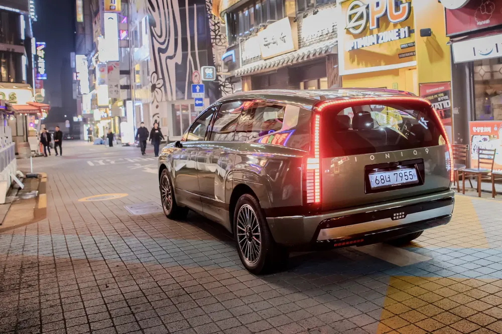 Hyundai Ioniq 7 stationné dans une rue lumineuse de nuit.