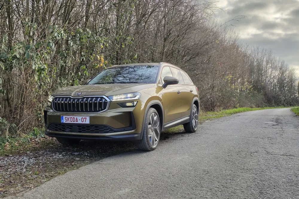 SUV Skoda sur une route boisée, ciel nuageux, design moderne.