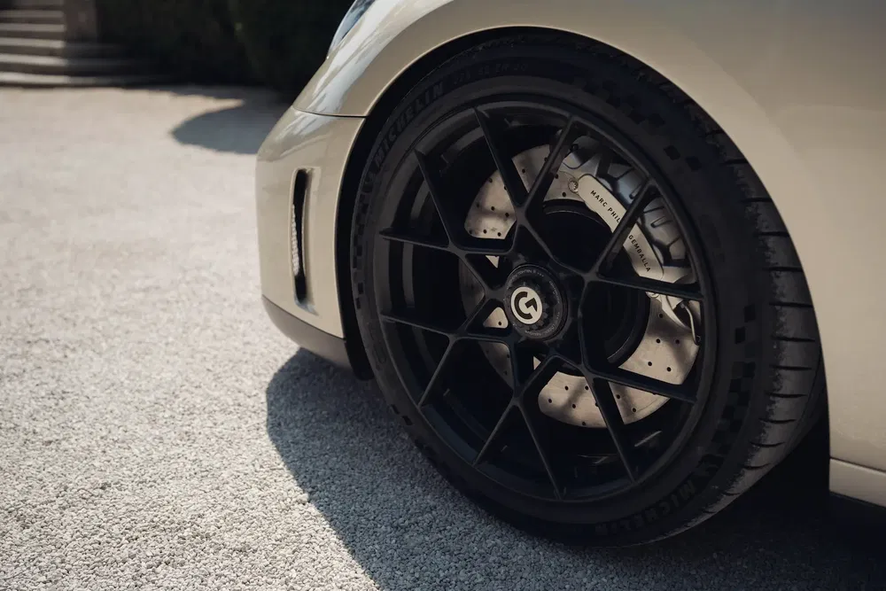 Roue d'une Bugatti Chiron avec jantes noir mat et freins Brembo visibles.