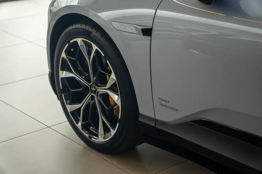 Détail de roue de la Polestar 4 grise dans une salle d'exposition.