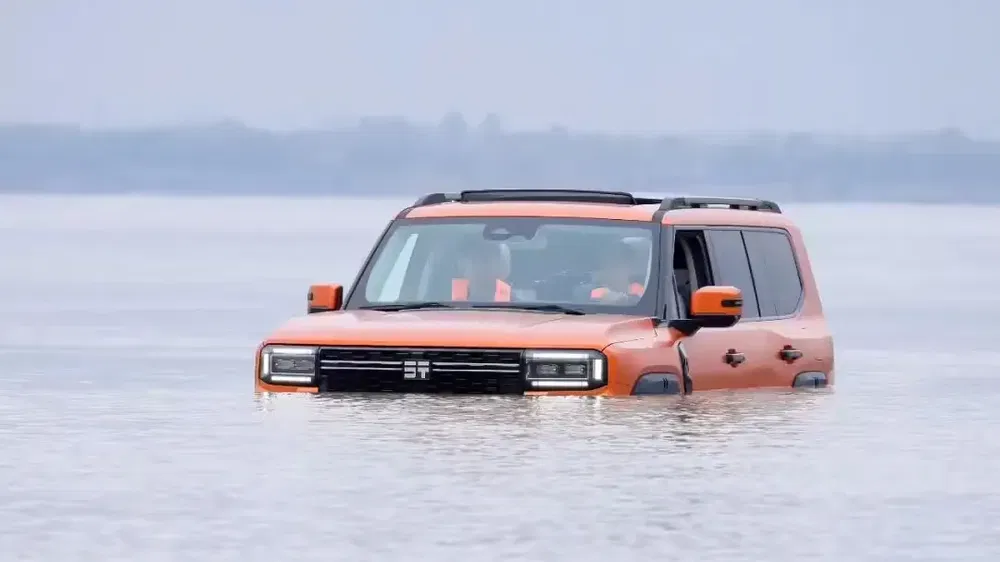 Oranje Hengchi SUV rijdt door water en toont indrukwekkende off-road capaciteiten.