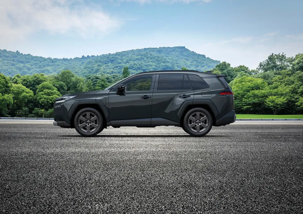 SUV Toyota profil latéral, stationné sur une route, paysage de montagnes en arrière-plan.