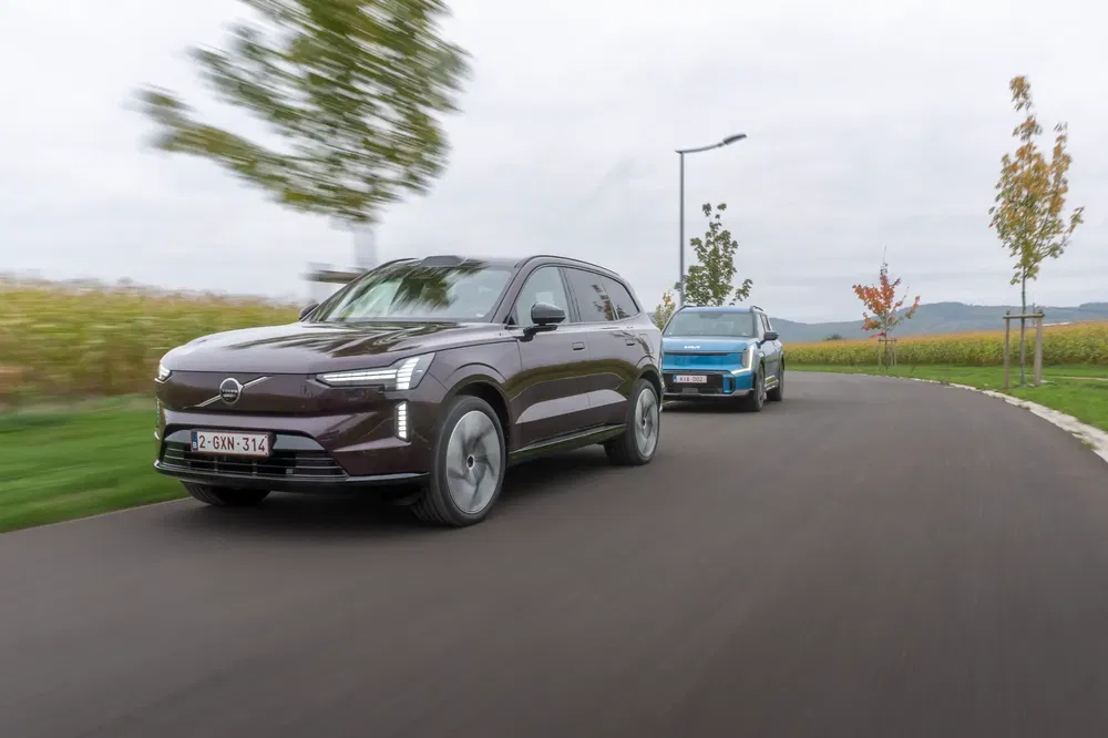 Volvo XC90 et SUV électrique sur route sinueuse en campagne automnale.