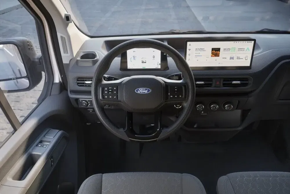 Moderne interieur van de Ford Transit met stuur en digitale schermen ingebouwd.