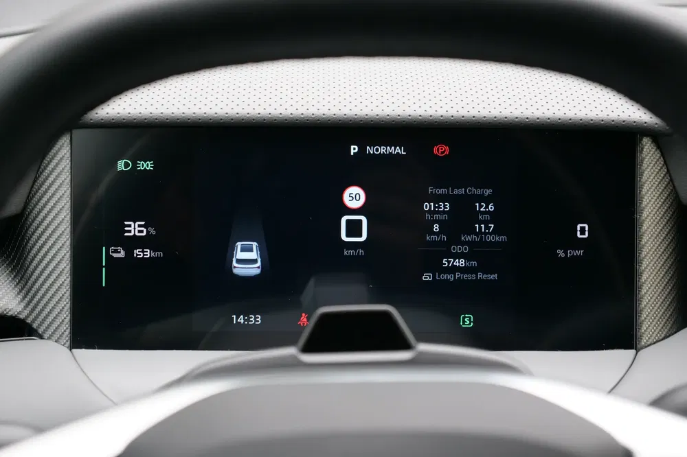 Tableau de bord numérique montre autonomie à 153 km et charge à 36% d'un véhicule électrique.