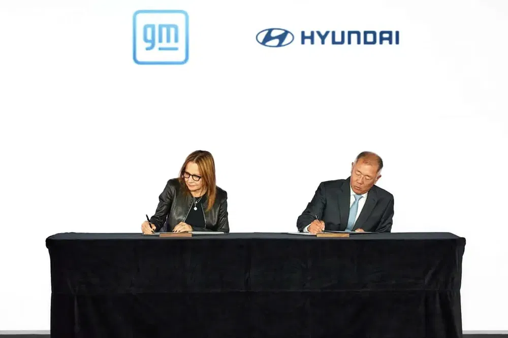 {"fr":"Personnes signant un accord sous les logos de GM et Hyundai lors d'une cérémonie officielle.","nl":"Mensen ondertekenen een overeenkomst onder de logo's van GM en Hyundai tijdens een ceremonie."}