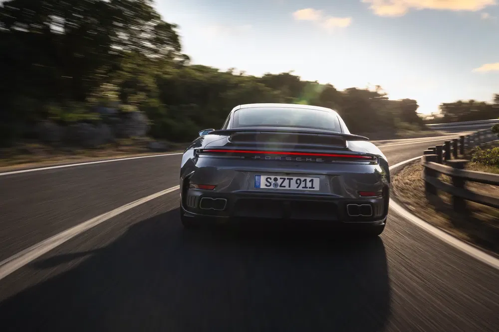 Porsche 911 German road virage, arrière voiture sport, conduite dynamique.