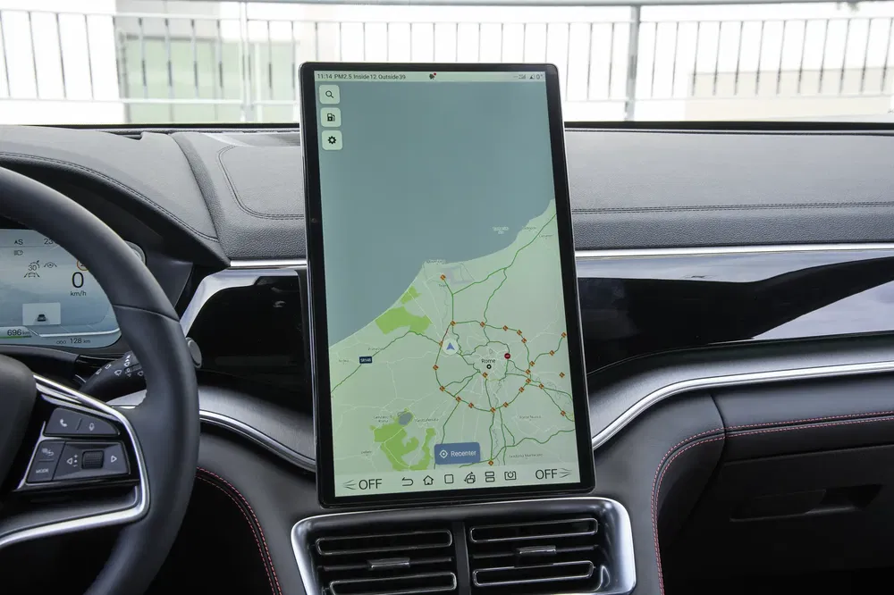 Écran d’infodivertissement vertical dans une voiture de luxe avec système de navigation intégré.