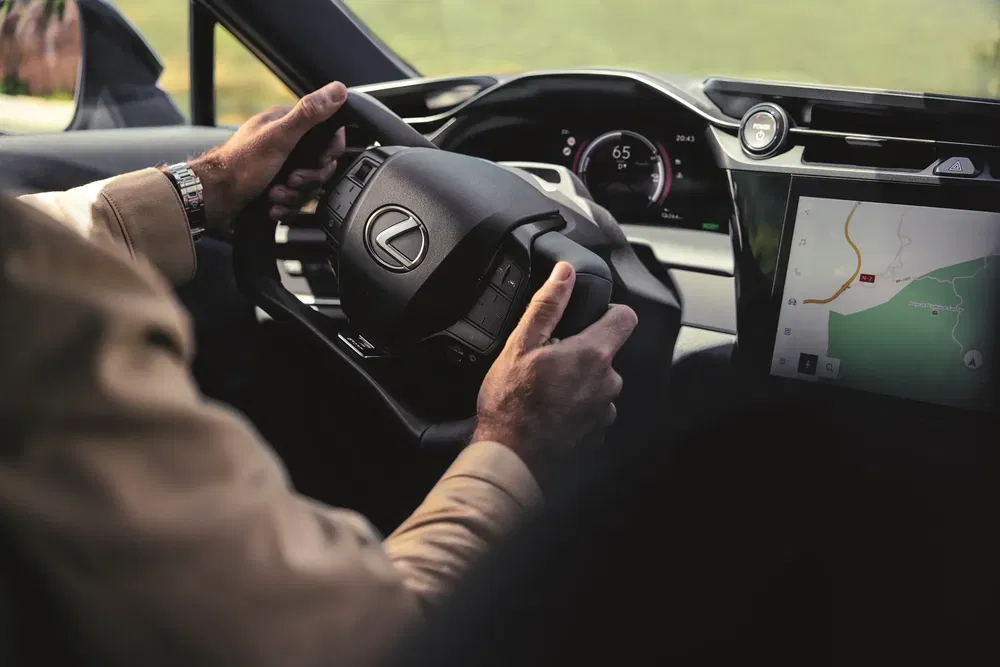 {"fr":"Conducteur tenant le volant d'une Lexus avec un écran GPS intégré.","nl":"Chauffeur houdt het stuur van een Lexus vast met ingebouwd GPS-scherm."}