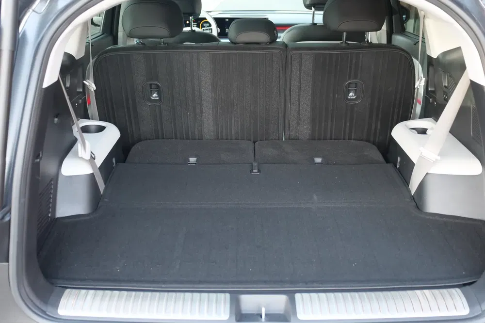 Grand coffre de voiture hybride avec sièges rabattus pour espace de chargement maximum.