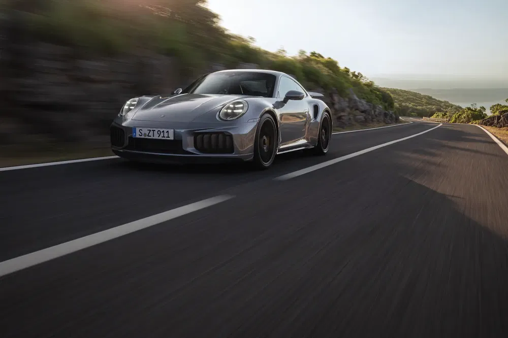 Porsche 911 sur route panoramique, performance et design aérodynamique en vedette.