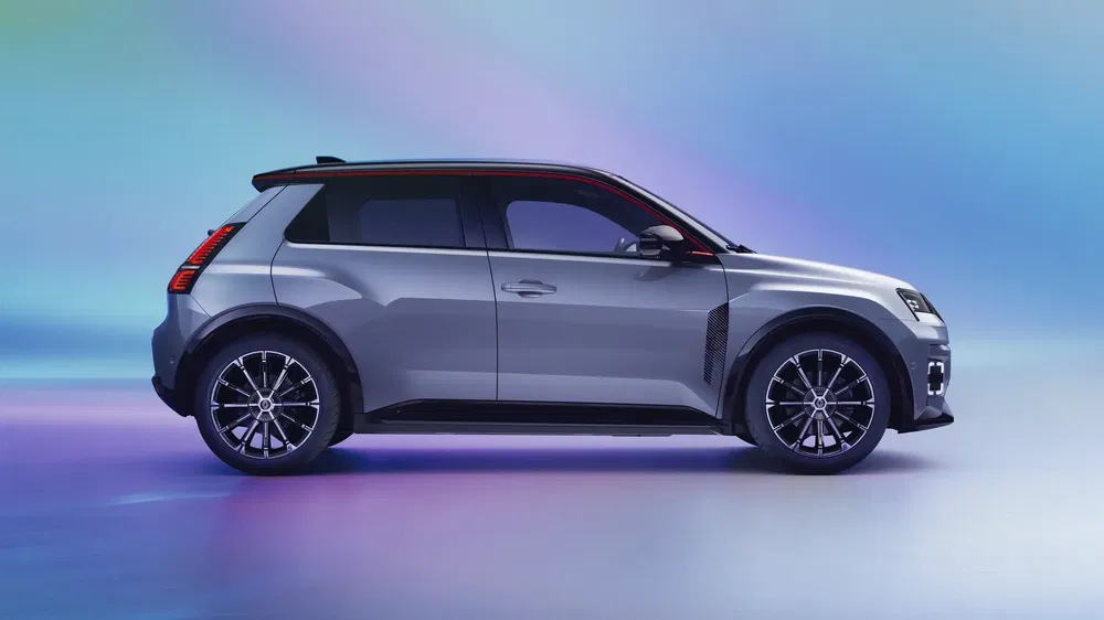 Renault 5 électrique, profil latéral élégant, teinte argentée, arrière-plan dégradé bleu et violet.