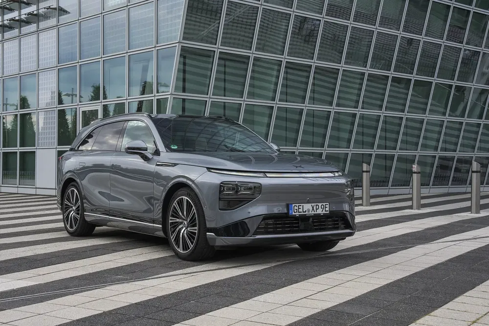 Stijlvolle elektrische XPeng G9 auto voor moderne glazen gebouw.