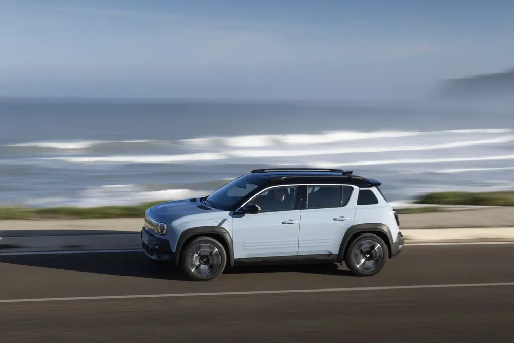 SUV compact roulant le long de la côte avec la mer en arrière-plan.