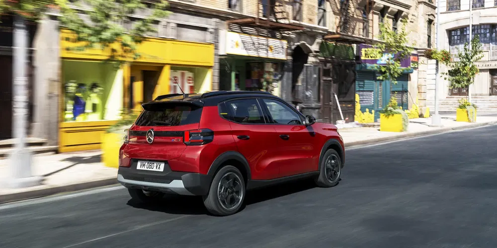 {"fr":"SUV Mercedes rouge roulant dans une rue urbaine avec bâtiments en arrière-plan.","nl":"Rode Mercedes SUV rijdt door een stedelijke straat met gebouwen op de achtergrond."}