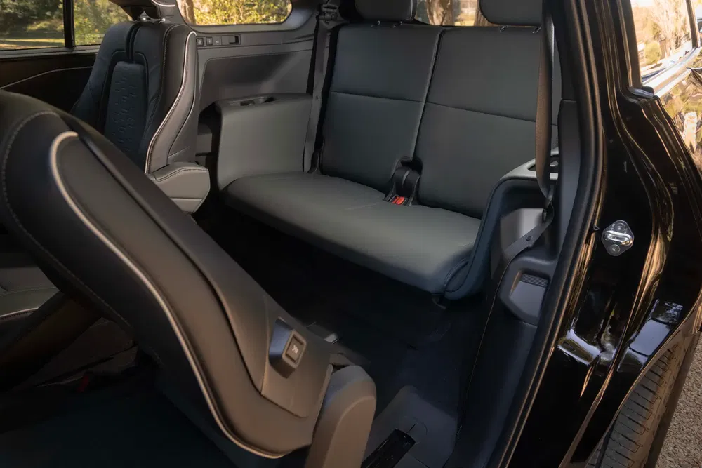 Intérieur spacieux de la Chevrolet Equinox 2024 noir, montrant les sièges arrière rabattables.