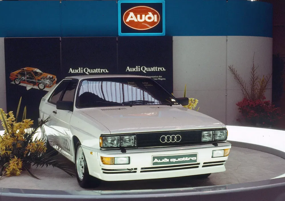 Audi Quattro blanche exposée, emblème Audi visible, modèle classique des années 80.