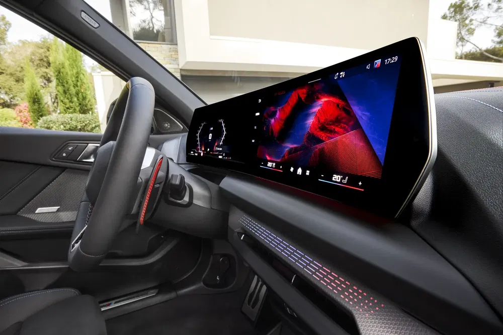 Tableau de bord numérique BMW avec écran large et interface moderne dans un intérieur élégant.