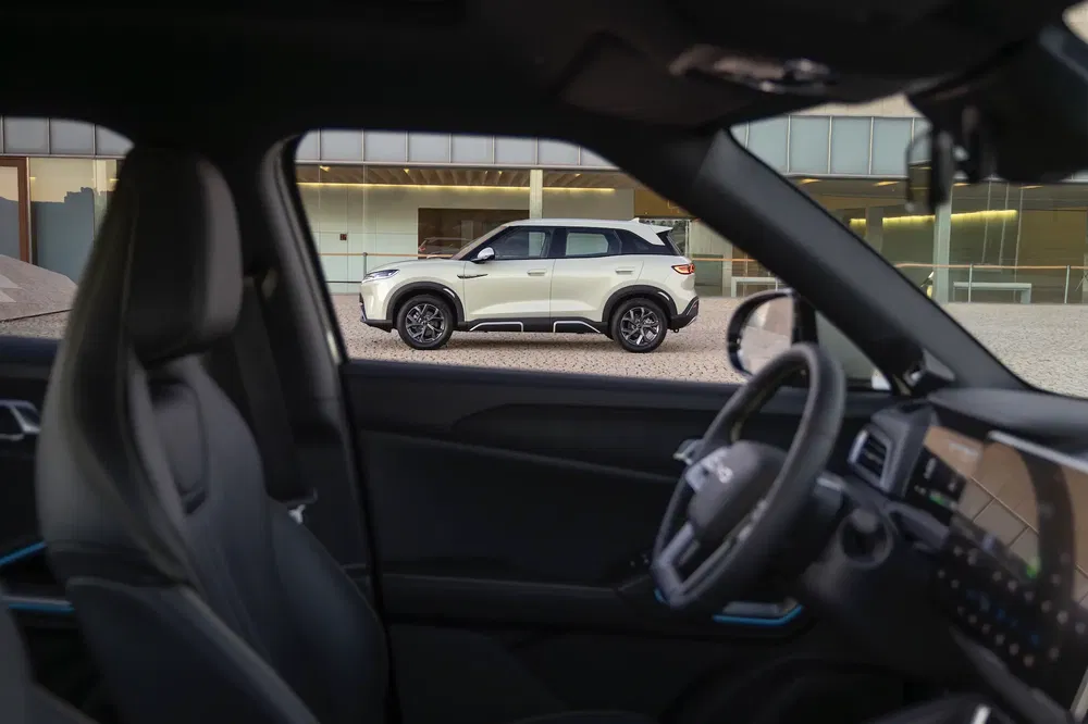 Vue intérieure de la Kia EV5 avec une Kia Sportage à l'extérieur.