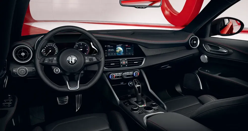 Intérieur moderne d'une Alfa Romeo Giulia avec volant en cuir et écran multimédia.
