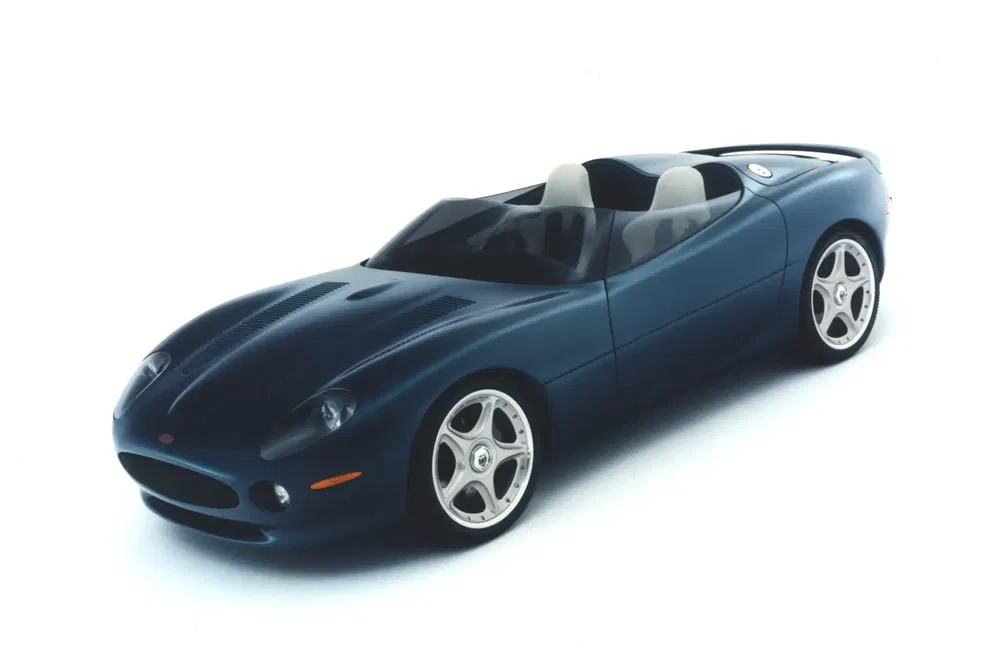 Voiture sport roadster bleue avec design aérodynamique et jantes argentées distinctives.