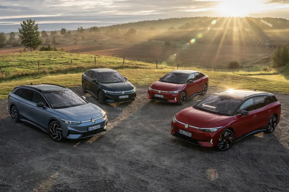 Quatre SUV Volkswagen électriques dans un paysage champêtre au coucher du soleil.