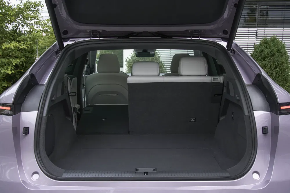 Coffre spacieux d'une voiture électrique Kia EV9, ouvert, avec sièges arrières rabattables.