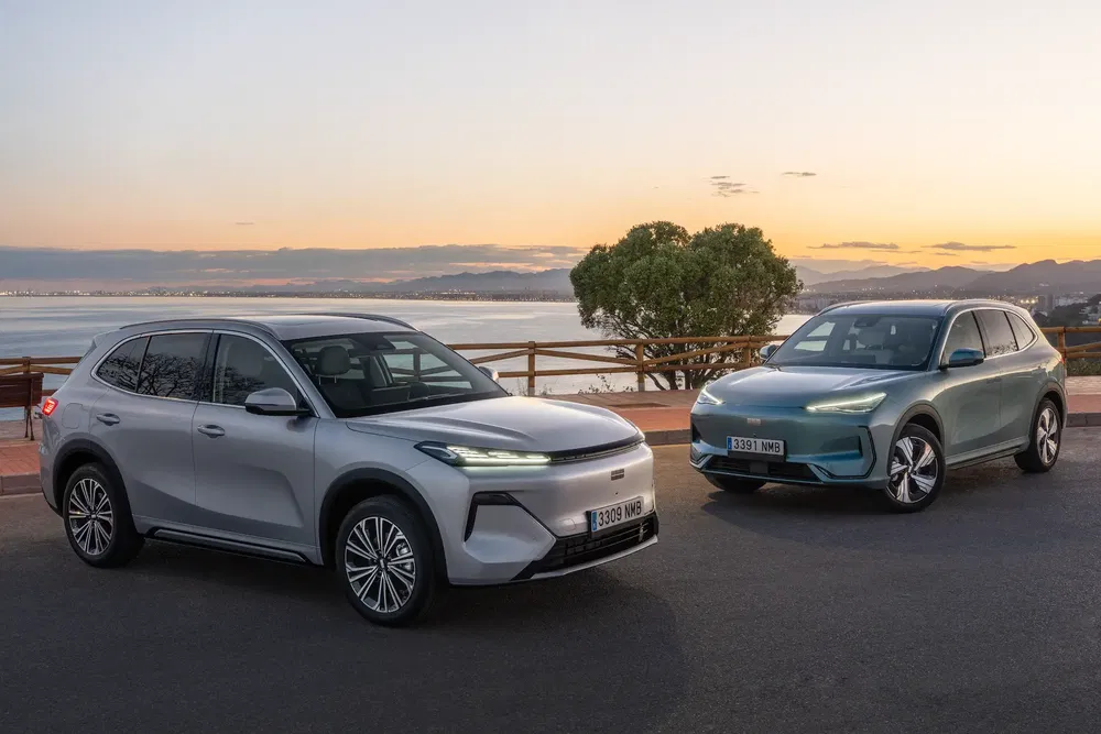 Deux SUV électriques BYD Tang au coucher du soleil près de la mer.