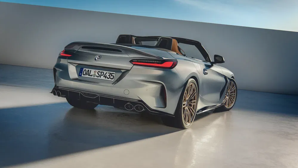 Cabriolet BMW Z4 argenté avec jantes en alliage doré et pare-chocs arrière sportif en plein air.