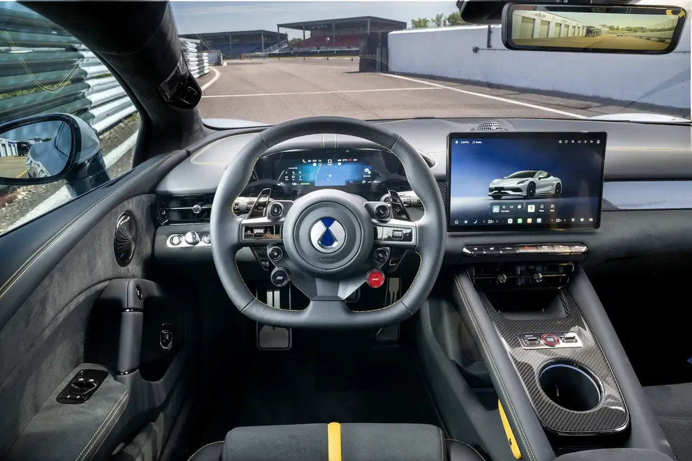 Intérieur high-tech d'une hypercar avec volant futuriste et grand écran tactile central.