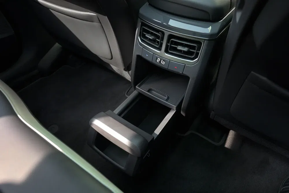 Intérieur voiture avec climatisation arrière et compartiment de rangement extractible.