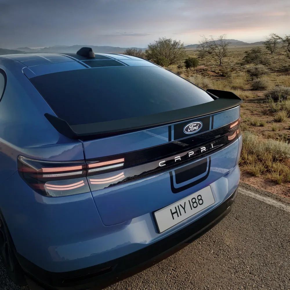 Achteraanzicht van de blauwe Ford Capri op een verlaten weg, modern en stijlvol ontwerp.