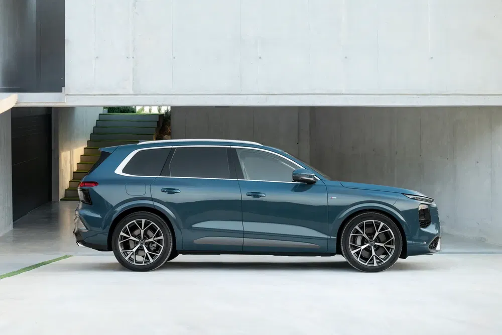 SUV électrique moderne, design élégant, couleur bleue, stationné devant un bâtiment minimaliste.
