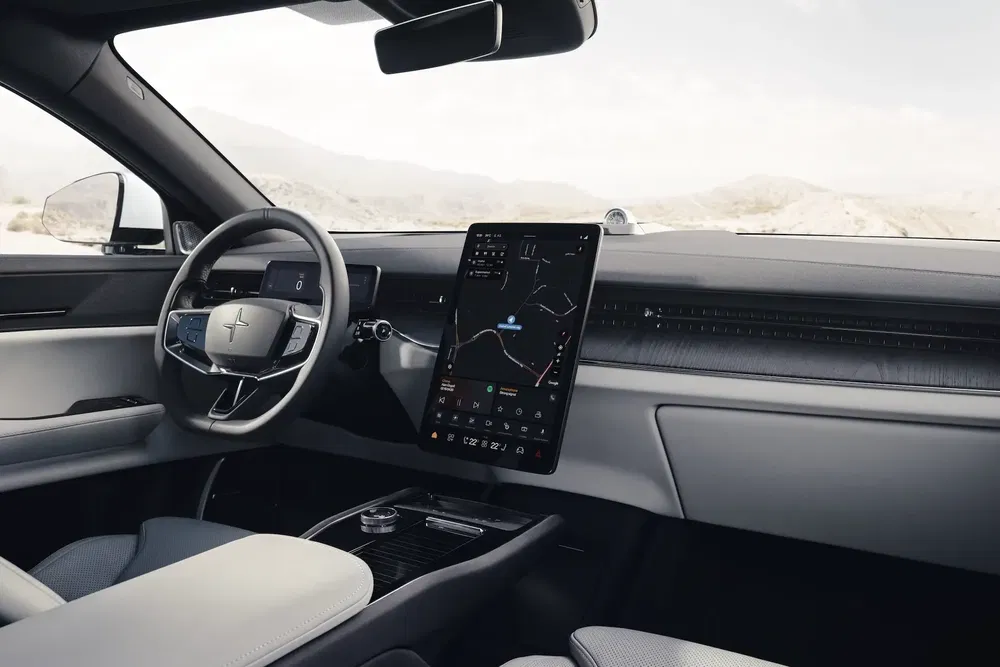 Intérieur moderne de Polestar avec écran tactile et volant élégant, vue panoramique des montagnes.