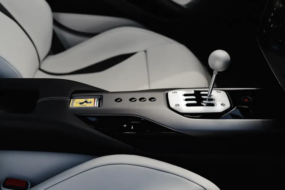 Intérieur de Ferrari avec boîte de vitesses manuelle et bouton de démarrage distinctif.