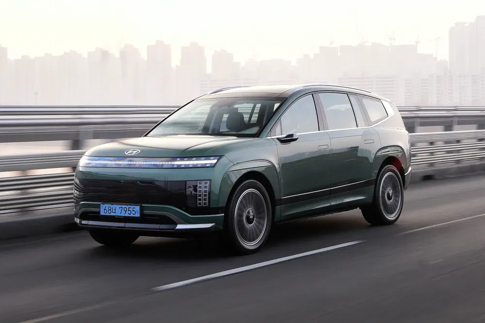 Hyundai SUV moderne roulant sur un pont au crépuscule, design élégant et urbain.