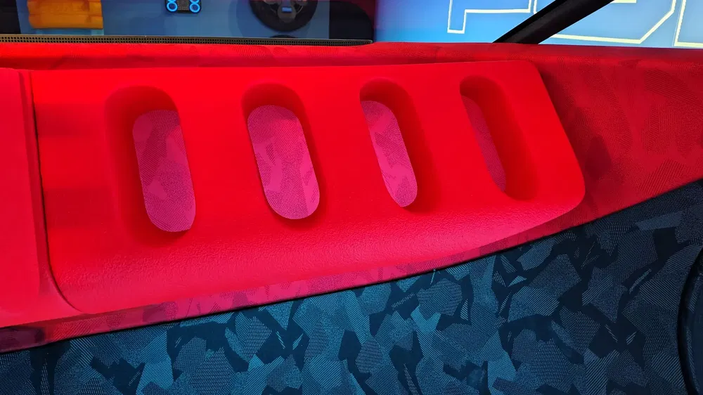 Intérieur de voiture moderne avec accoudoir rouge et motifs bleus texturés.