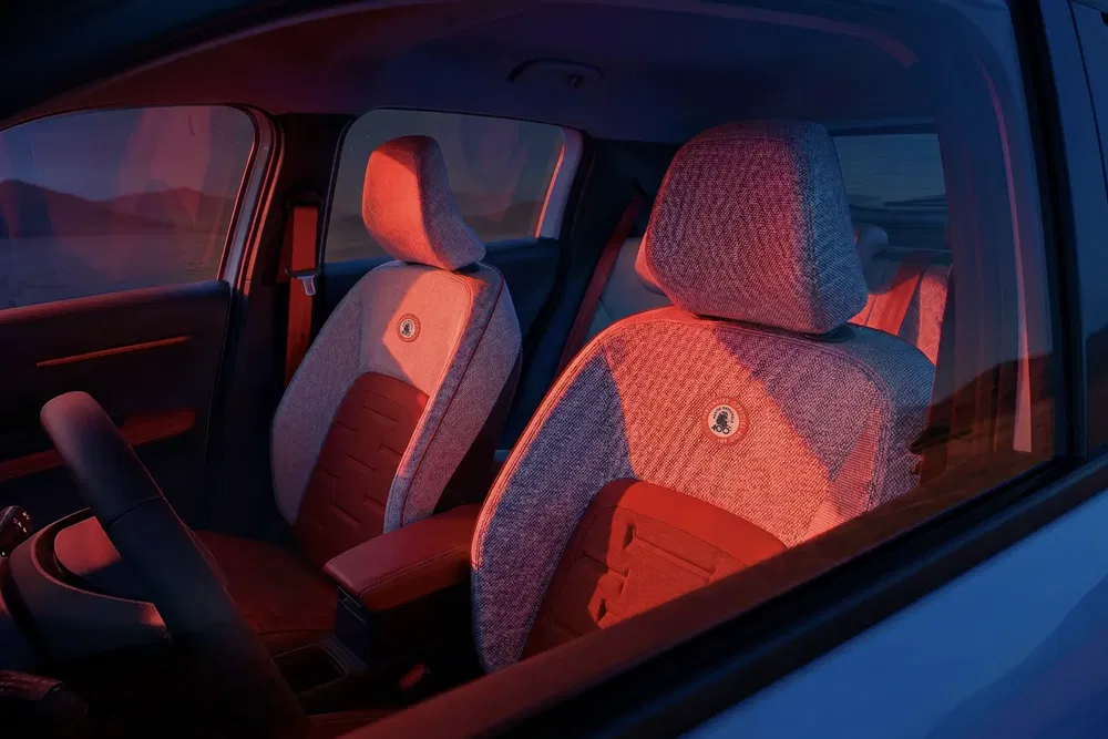 Interieur van de Fiat 600, rode sfeerverlichting, stijlvolle stoffen voorstoelen.